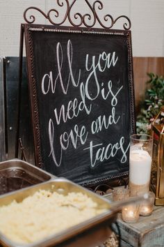 a sign that says all you need is love and tacos next to some food