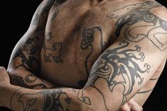 a man with tattoos on his arm and chest