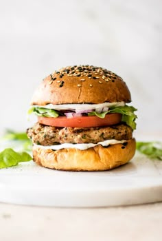 an easy turkey burger with lettuce, tomato and cheese on a white plate