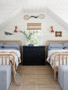 there are two beds in the attic with blue and white beddings on them