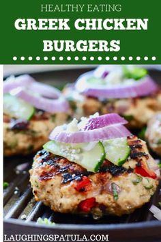 chicken burgers with cucumber and red onion on top, sitting on a grill