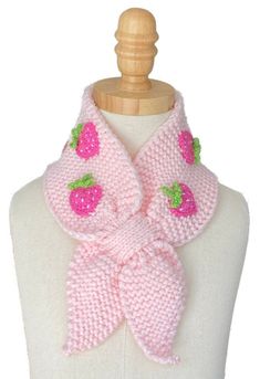 a pink knitted scarf with strawberries on the front and green leaves on the back