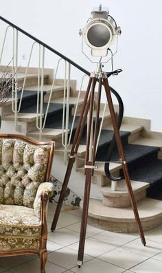 a chair sitting in front of a camera on top of a tripod next to a stair case