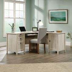 a desk with a laptop on it and a chair next to it in front of a window