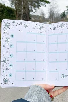 someone holding up a planner with snowflakes on it