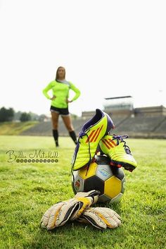 a woman standing in front of a soccer ball