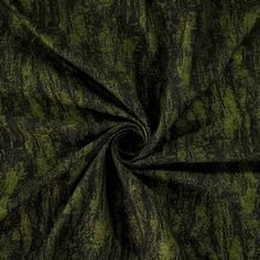 a green and black fabric with an uneven design on the bottom, it is very dark