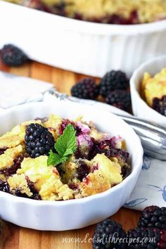 a bowl filled with blackberries and cream cheese dump cake