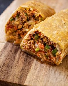 a burrito cut in half sitting on top of a wooden cutting board with the words machaca breakfast burrito smoked and simple