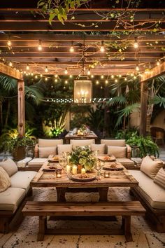 an outdoor dining area with couches, tables and lights