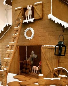 a gingerbread house is decorated with animals and other decorations for the christmas holiday season