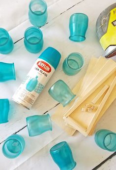 blue glass cups and glue sitting on top of a table