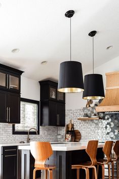 a kitchen with black cabinets and wooden stools