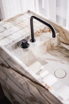 a marble sink with a black faucet in it