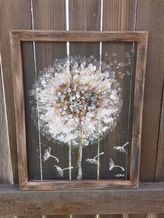 a dandelion painted on the side of a wooden frame