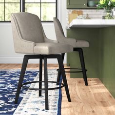 two stools in the middle of a kitchen with an area rug on the floor