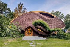 an unusual house in the middle of some trees