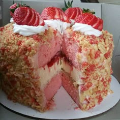 a cake with strawberries on top is cut in half and ready to be eaten