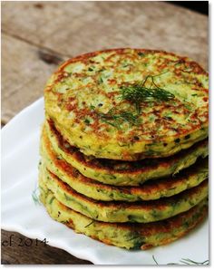 a stack of food sitting on top of a white plate next to a wooden table