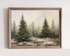 a painting hanging on the wall next to a white wall with a brown frame and some trees