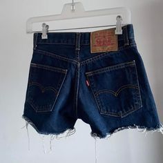 1980s vintage Levi's shorts for women model 535. Dark blue color,  distressed cut off. A perfect vintage clothing item for you for this summer Material: 100% cotton Era: 1980's ∙ mid to high rise  ∙ button fly  ∙ red tab  ∙ raw hem  Size: Eu S (34) Measurements: - Waist 64 cm / 25,1 inches - Hips 92 cm /  36,2 inches - Length: 31 cm / 12,2 inches The shorts are pre-owned, but they're in perfect condition, are cleaned, and are ready to meet their new happy owner.  If you have any questions, I can 90s Style Frayed Hem Cutoff Jean Shorts, 90s Style Dark Wash Jean Shorts, Vintage High Rise Jean Shorts With Frayed Hem, High Rise Vintage Jean Shorts With Frayed Hem, Vintage Dark Wash Shorts For Summer, Vintage Medium Wash Jean Shorts With Frayed Hem, Vintage Dark Wash Jean Shorts For Summer, Vintage Short Jeans With Frayed Hem, Retro Cutoff Jean Shorts With Frayed Hem