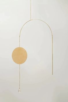 a wind chime hanging from the ceiling in front of a white wall and floor