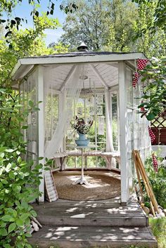 a white gazebo surrounded by greenery and trees