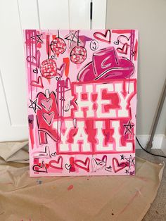 a painting that is on top of a piece of cardboard with words and hearts painted all over it