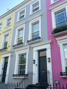 two multi - colored buildings with black wrought iron railings