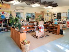 the inside of a store with lots of items on shelves and plants hanging from the ceiling