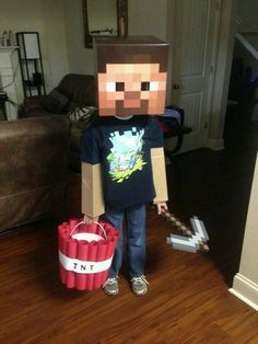 a young boy in a minecraft costume holding a red bag and wearing a paper mache