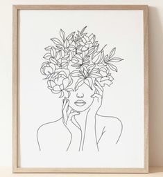 a black and white drawing of a woman with flowers in her hair on the wall