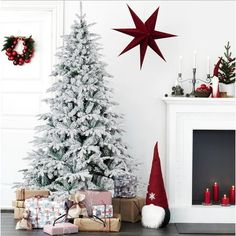 a christmas tree with presents under it next to a fire place and other holiday decorations