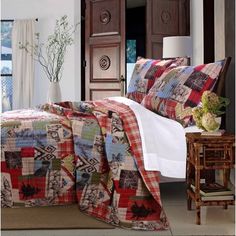 a bedroom with a bed covered in a colorful patchwork quilt and matching throw pillows