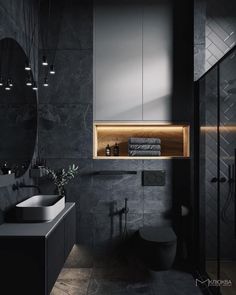 a modern bathroom with black walls and flooring is shown in this image, there are lights above the sink