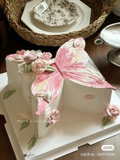 there is a cake decorated with pink flowers and a butterfly on the top of it