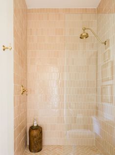 a bathroom with a toilet and shower in it's corner, next to a tiled wall