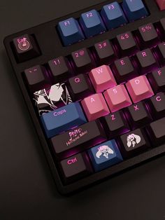 a computer keyboard with pink and blue keys