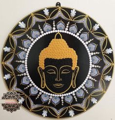 a black and gold plate with a buddha face on it