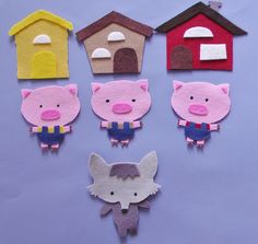 paper cut out animals and houses on a blue surface with one pig in the middle