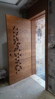 two wooden doors with designs on them in an unfinished room next to a newspaper rack