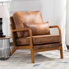 a brown leather chair sitting on top of a rug next to a lamp and table