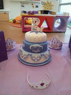 a three tiered cake sitting on top of a table next to purple and white napkins