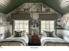 two beds in a room with deer wallpaper