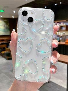 a person holding up a phone case with some beads on it's back cover