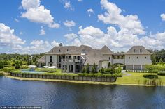 an aerial view of a large house on the water's edge with a swimming pool