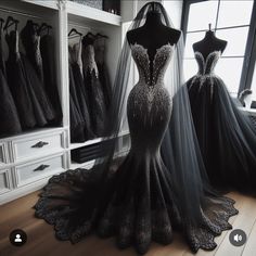 two dresses are on display in a room with white cabinets and black gowns behind them