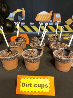 dirt cups with spoons in them sitting on a table at a construction themed birthday party