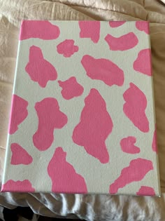 a pink and white animal print canvas on a bed