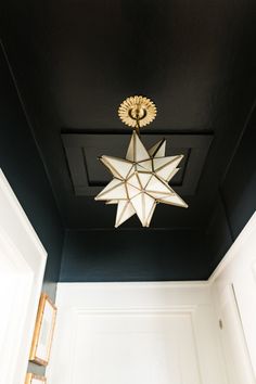 a light fixture hanging from the ceiling in a room with black walls and white trim